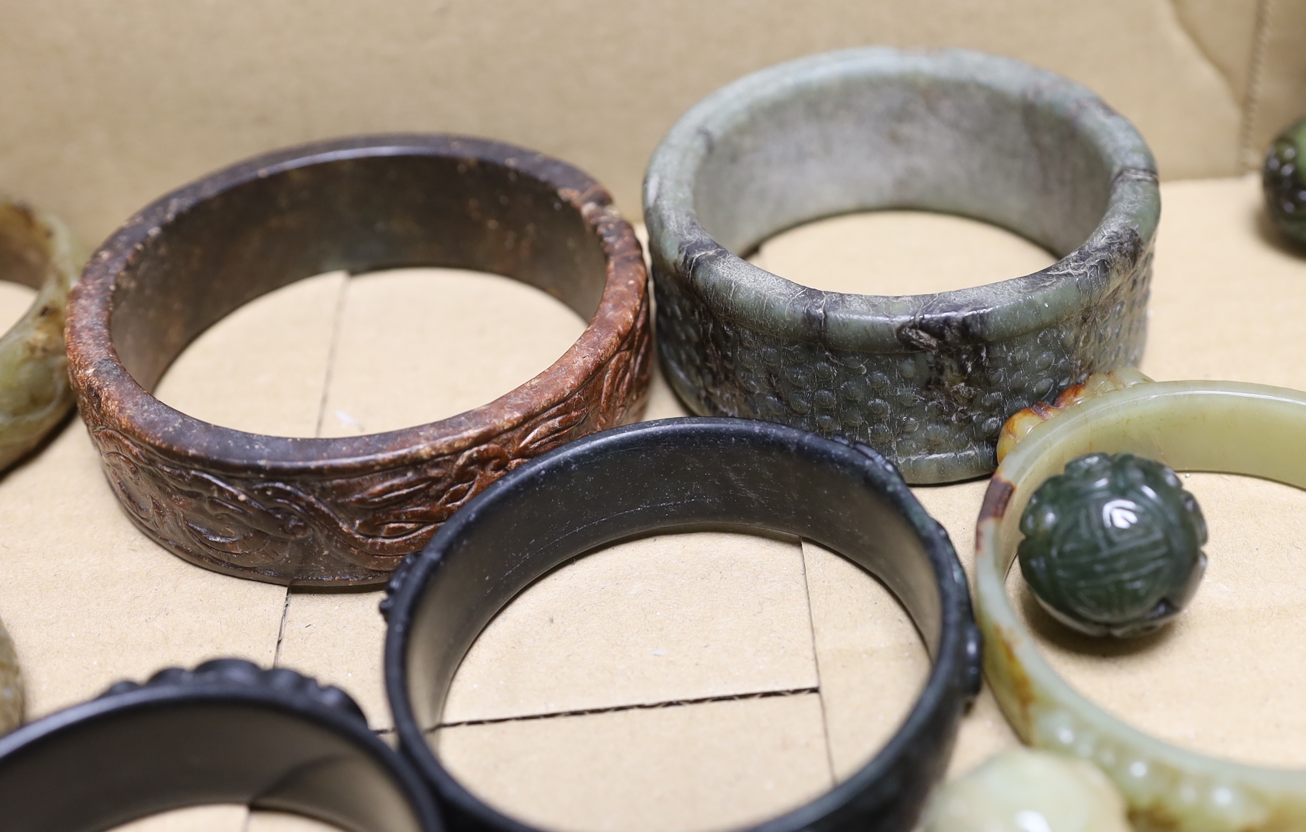 Nine assorted Chinese jade and hardstone bangles and three spheres, largest bangle 8.5cm diameter